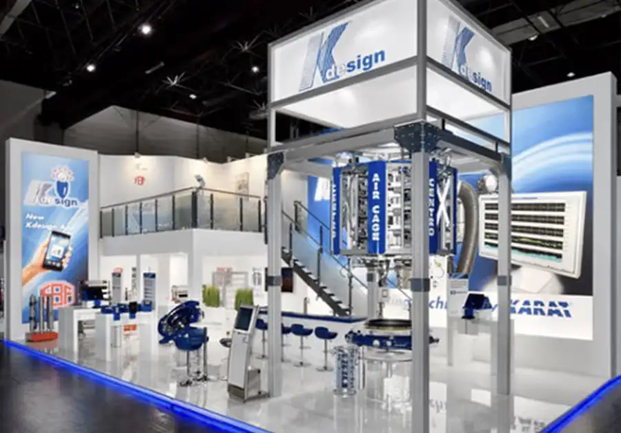 Messestand K-design – Lüco Messebau Von Lüco gebauter zweigeschossiger Messestand in Blau-Weiß mit Treppe und technischer Anlage